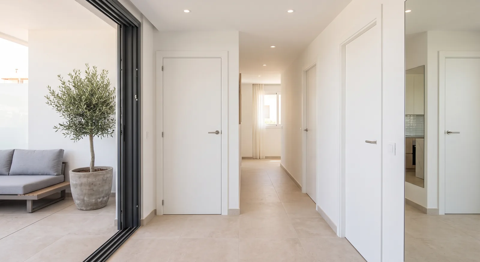 Pasillo de un apartamento reformado con puertas lacadas en blanco y suelo porcelánico claro (imagen ilustrativa)